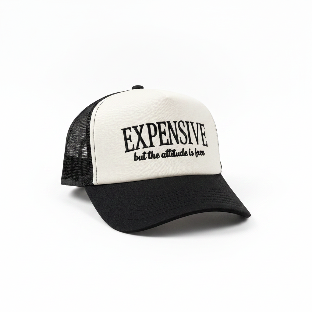 White and black trucker hat with Expensive But The Attitude Is Free embroidered text